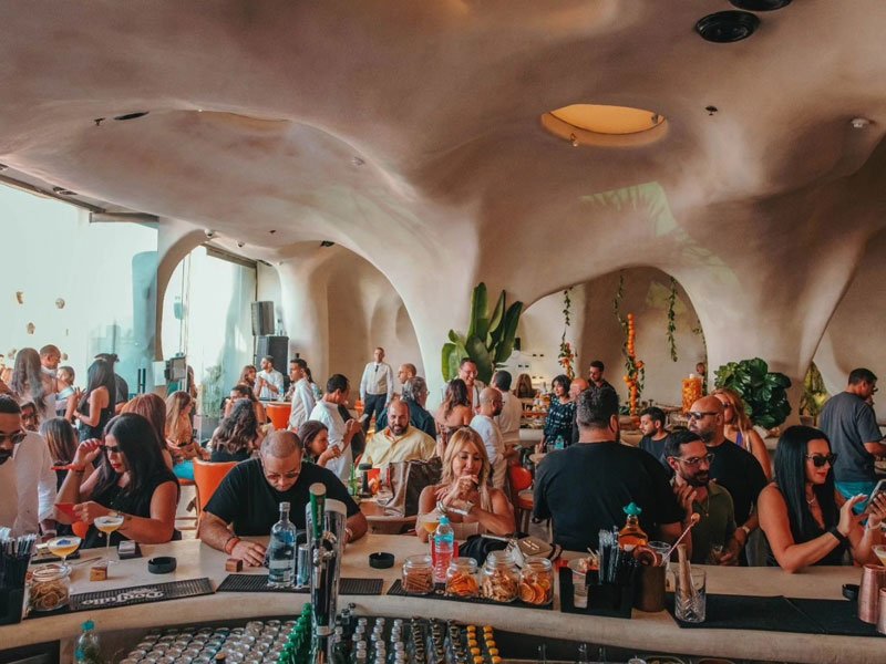 Upscale outdoor event with decorative lighting and seated guests