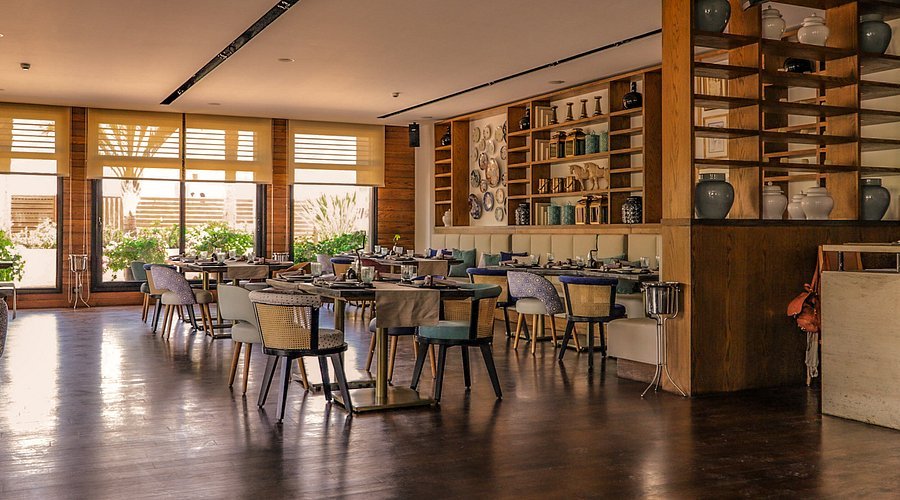 Elegant restaurant interior with warm wood tones, ceramic shelving, and natural light