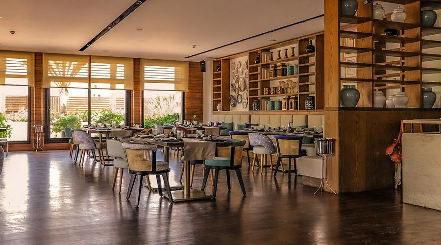 Elegant restaurant interior with warm wood tones, ceramic shelving, and natural light