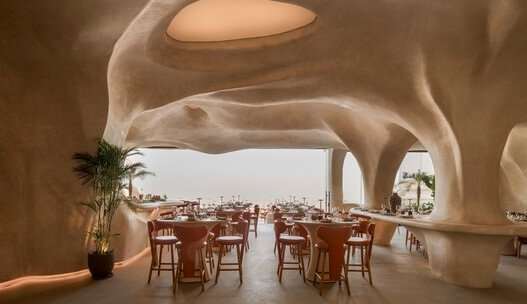 Architecturally stunning restaurant interior with organic sculpted arches and ocean views